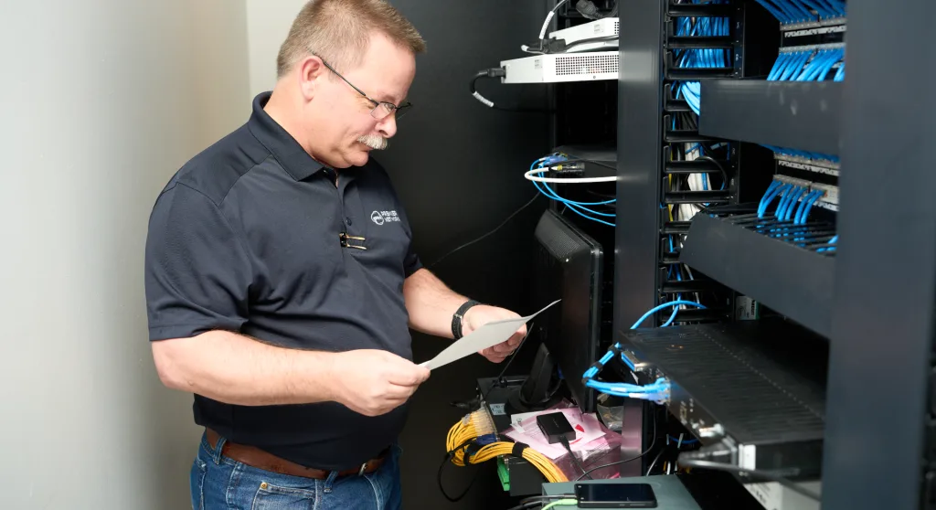 cabling technician working to install network cabling, one of our IT services